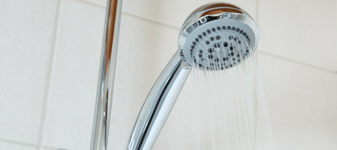 A stainless steel showerhead that has been turned on