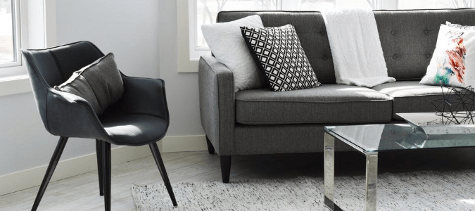 A light grey living room with a dark grey couch and freshly painted white trim