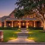 a home with outdoor lighting by its front walkway