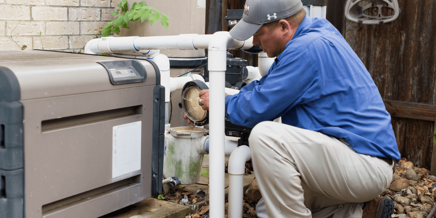 a certified pool and spa professional repairing a homeowner’s pool pump