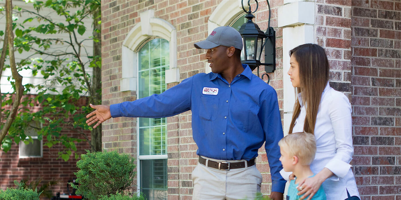 a pest control specialist talking to a homeowner about pre-construction termite control