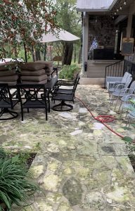 A stone patio before being power washed