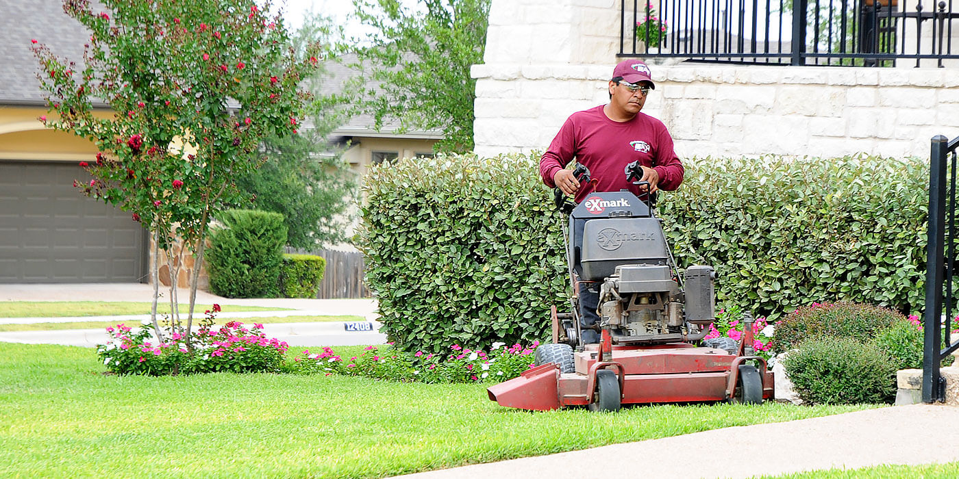 an ABC lawn care specialist providing lawn maintenance services