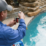 a specialist adding chemicals to a pool as part of the pool cleaning service