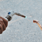 un especialista haciendo reparaciones a las tuberías de agua de una casa