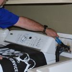 an appliance repair specialist fixing a homeowner’s washer