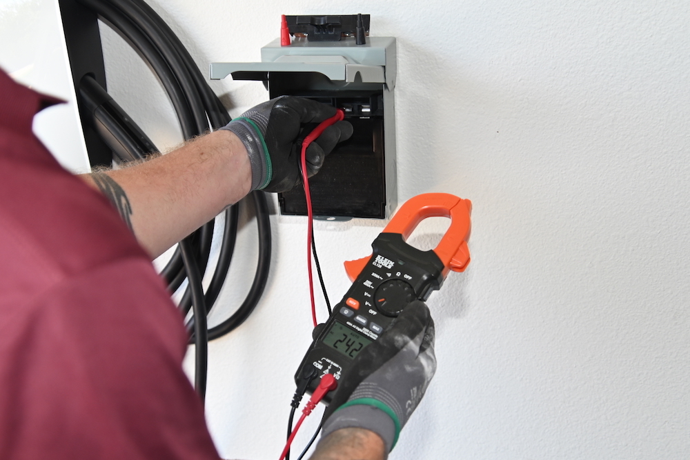 An electric vehicle charging station is being installed by an electrician