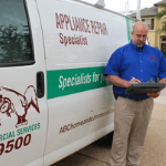 An ABC appliance tune-up specialist standing next to his van