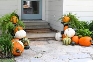 a medium size pile of pumpkins on a front stoop