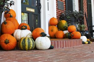 a large pile of pumpkins on a front stoop