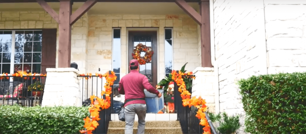 ABC team member carrying holiday lights to the porch of a house to prepare instillation