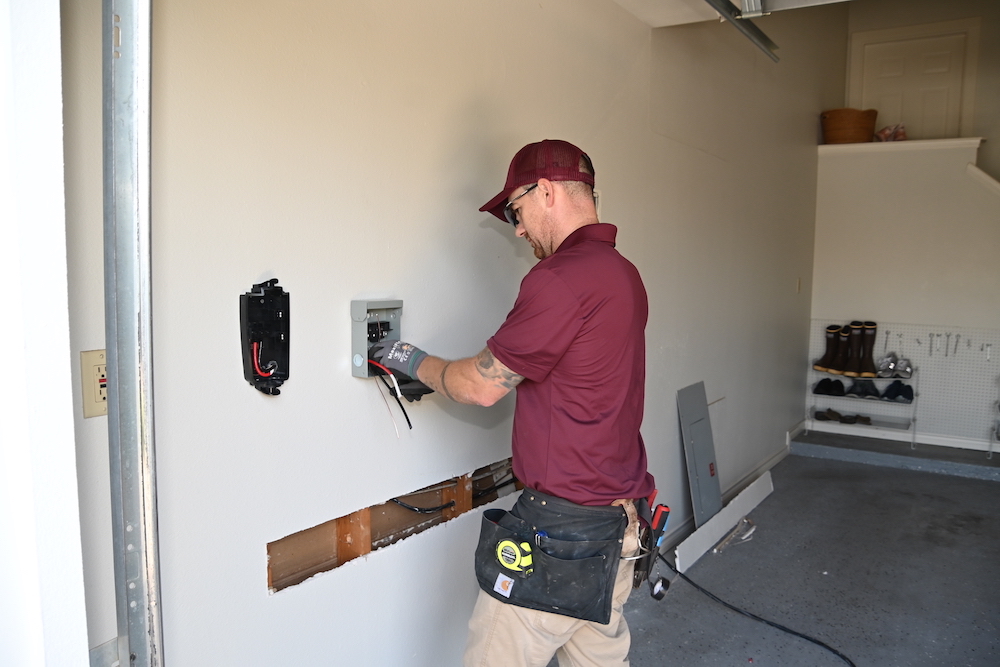 An electrician installing an EV charger in a garage