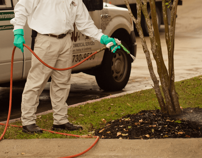 an ABC lawn care specialist fertilizing a commercial lawn