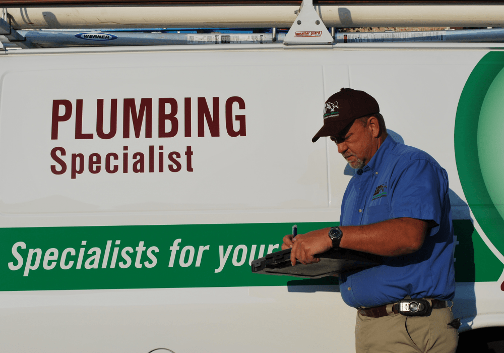a commercial plumber writing a report of the plumbing services provided for a business
