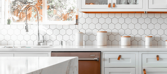 a kitchen with granite countertops and white backsplash