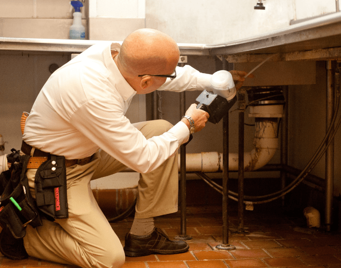 an ABC commercial pest control technician performing an inspection at a restaurant