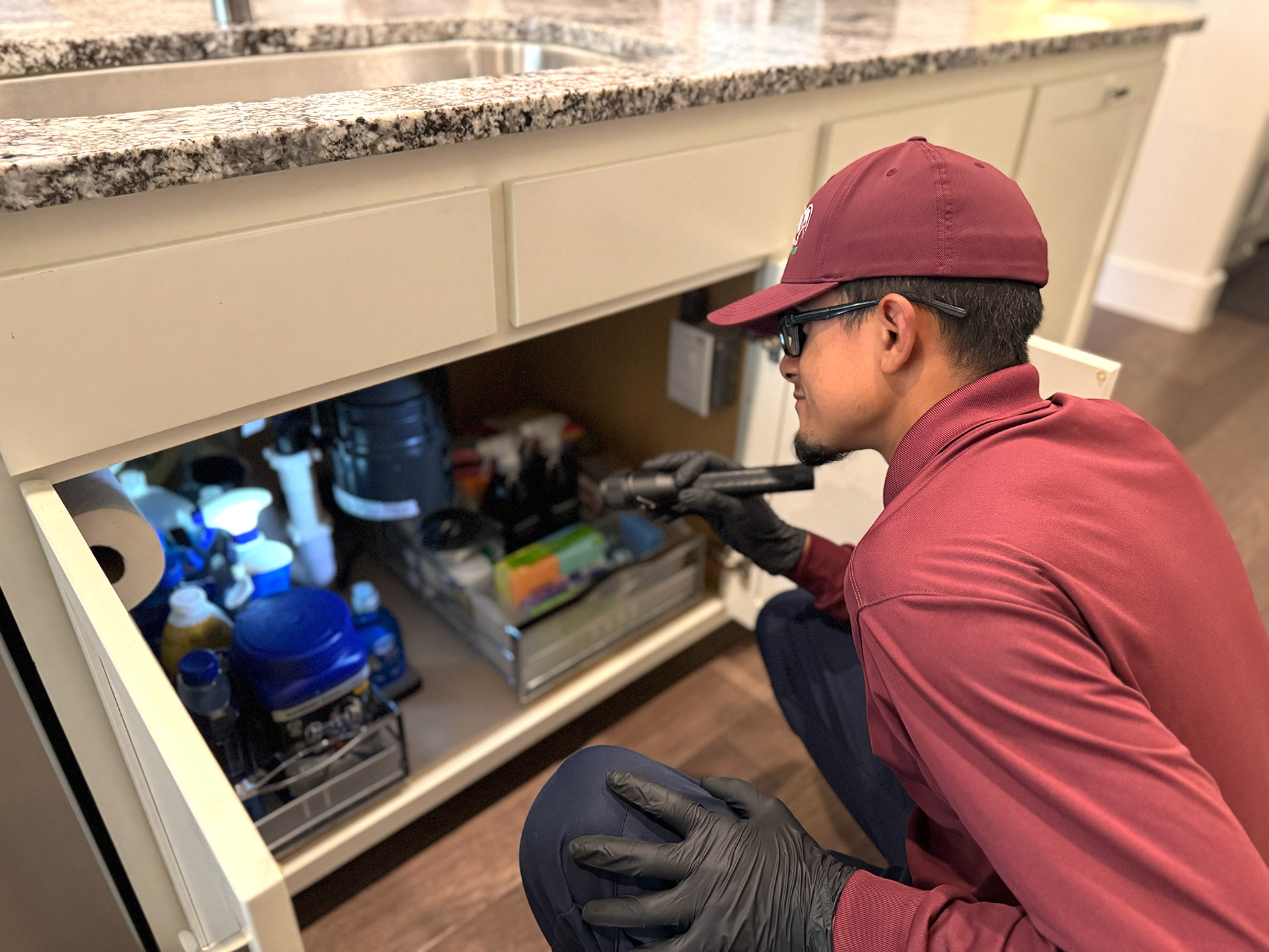ABC technician inspecting the inside of a cabinet for pests