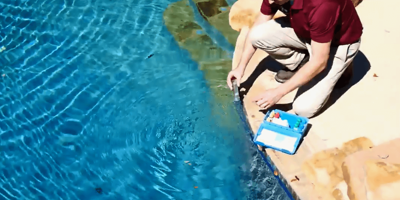 a certified pool professional cleaning a homeowner’s pool