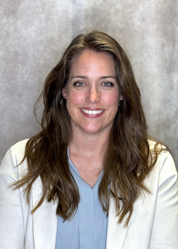 Picture of Landscaper Amanda North in a suit jacket with grey background.