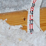 a tape measure showing the depth of insulation
