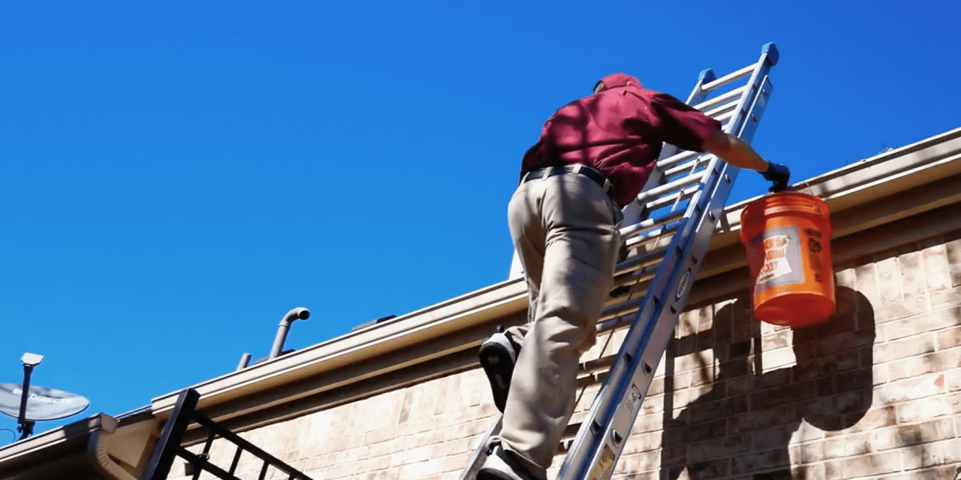 specialists cleaning out a homeowner’s gutters