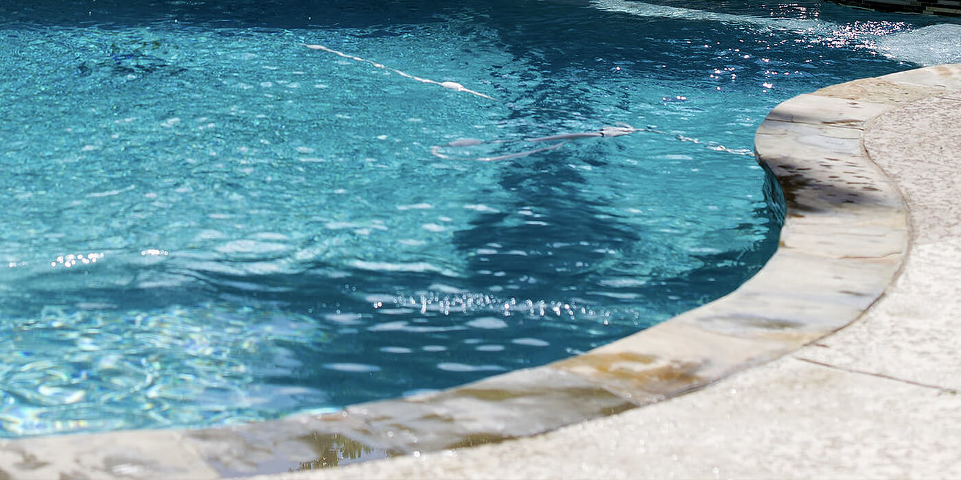 sparkling blue water in an outdoor pool that has been replastered by ABC specialists