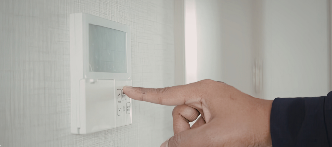 a person adjusting a thermostat