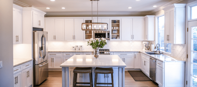A white kitchen with flowers on the table