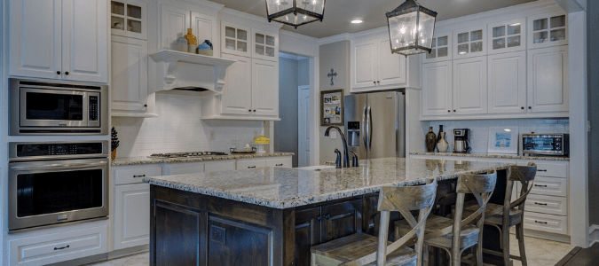 a white kitchen with granite countertops