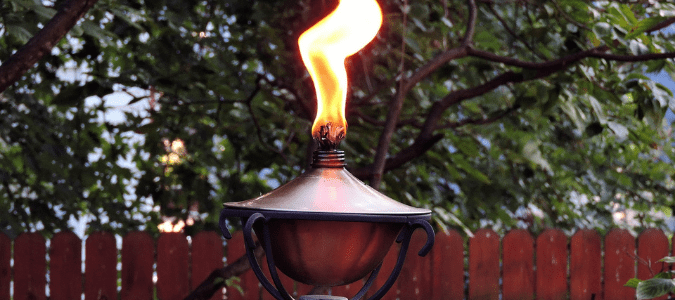 a lit tiki torch in hopes the smoke will keep mosquitoes away