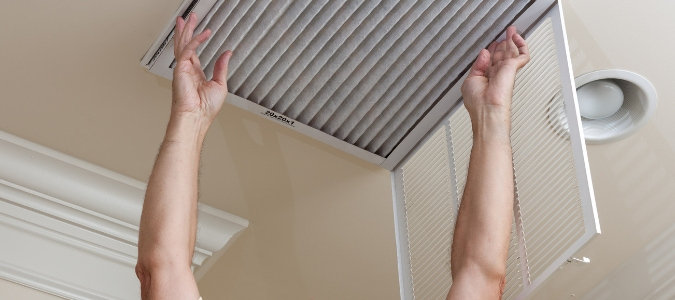 a homeowner changing out their air filter to clean it