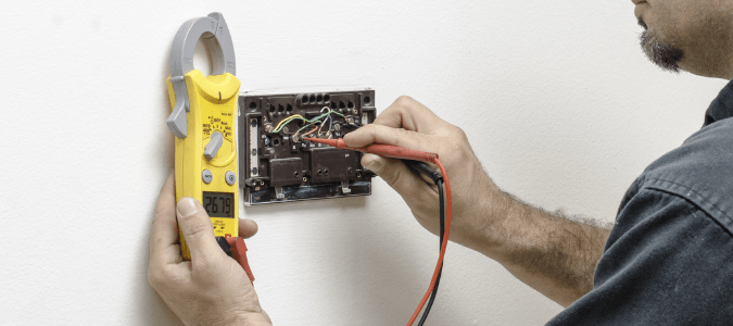 an HVAC professional testing a thermostat