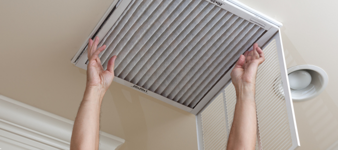 hands adjusting an air filter in a vent