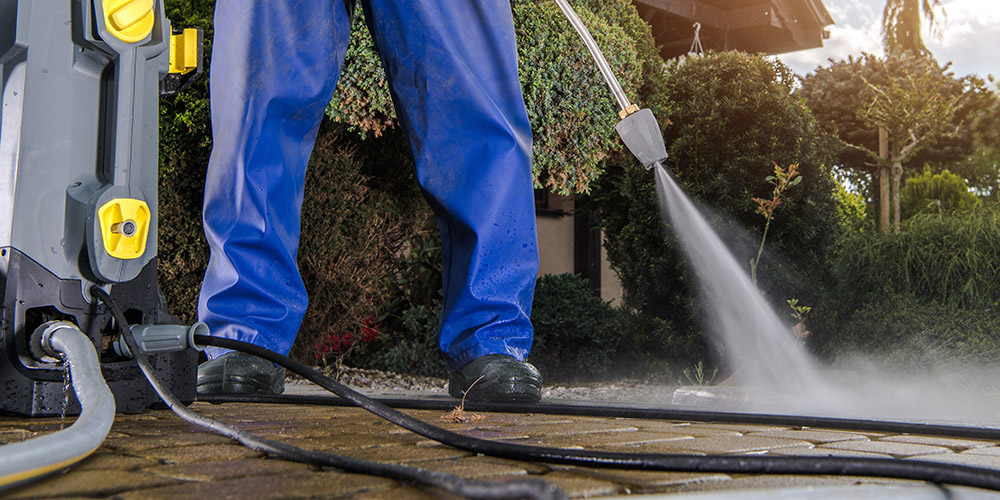 A person is using a pressure washer - Regular Exterior Cleaning - ABC Home and Commercial Services