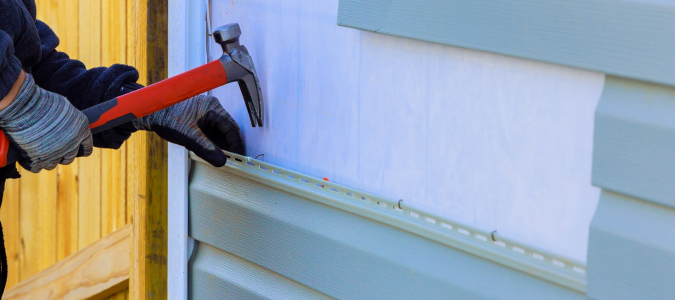 handyman repairing exterior siding