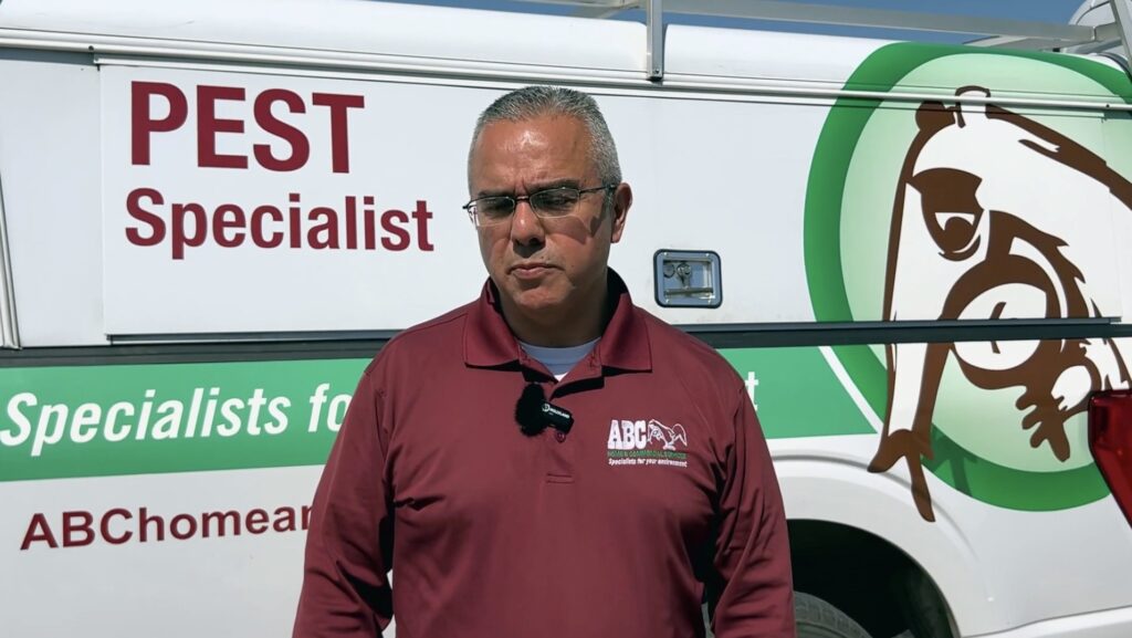 A pest specialist in front of his ABC work truck