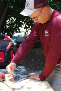 an ABC handyman measuring for a project