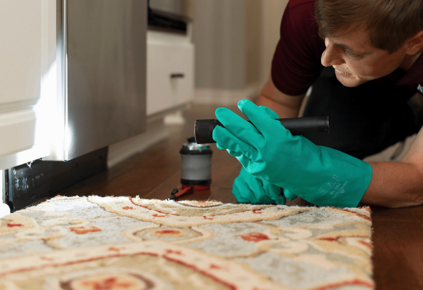 an ABC pest control specialist performing an inspection for a homeowner’s cockroach problem